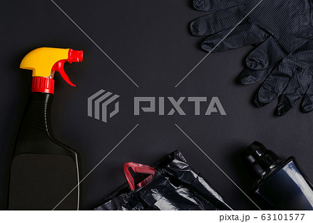 Plastic spray bottles, garbage bags and rubber gloves on a black background. 63101577
