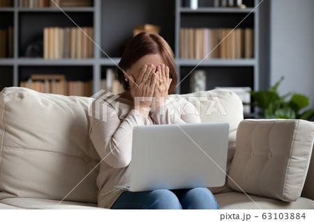 Stressed middle aged woman hiding face with both hands. Stressed middle aged woman hiding face with both hands. 63103884