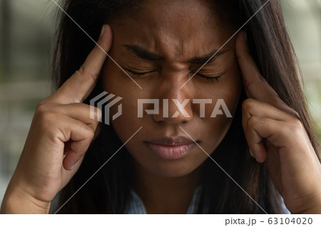 Unhealthy biracial woman suffer from migraine at work Unhealthy biracial woman suffer from migraine at work 63104020