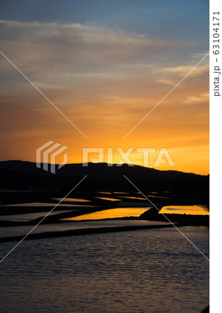 田植え前の水田に映る夕日 63104171