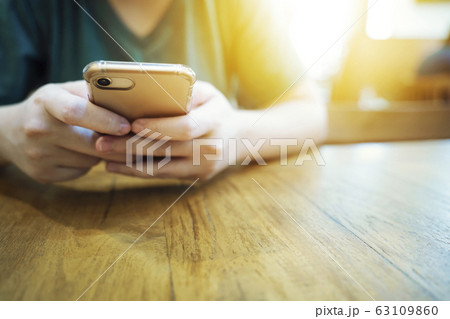 Closeup of hands using mobile in cafe. Modern Closeup of hands using mobile in cafe. Modern 63109860
