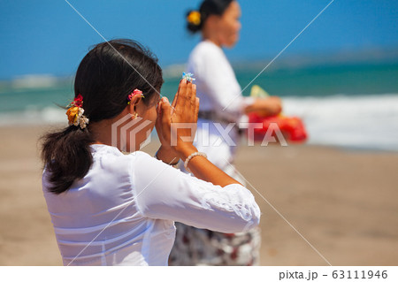 Young balinese women praying with namaste hands on 63111946