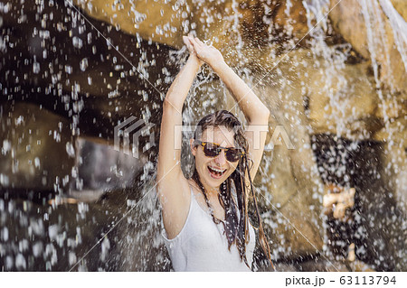 Young joyful woman under the water stream, pool, day spa, hot springs Young joyful woman under the water stream, pool, day spa, hot springs 63113794
