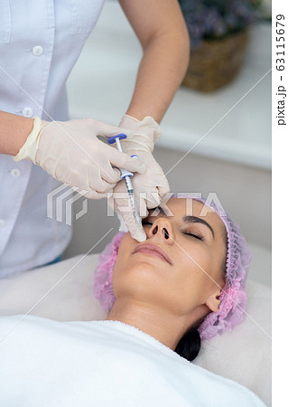 Cosmetologist wearing gloves doing mesotherapy for patient Cosmetologist wearing gloves doing mesotherapy for patient 63115679