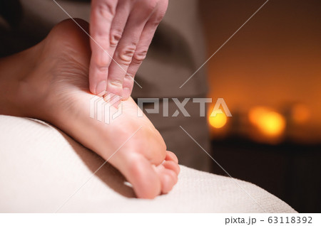 Close-up reflexology foot massage. Male masseur makes foot massage to a female client. Foot Care Concept Close-up reflexology foot massage. Male masseur makes foot massage to a female client. Foot Care Concept 63118392