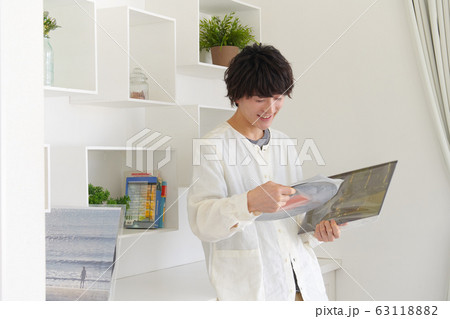 レコードジャケットとレコードを見る若い男性 63118882