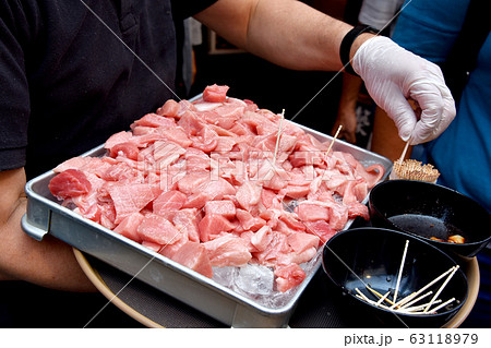 Free food sample tasting, Salesman serving fresh otoro tuna fish sampling to customer. 63118979