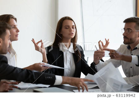 Mindful young business woman meditating, managing stress. Mindful young business woman meditating, managing stress. 63119942