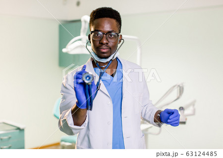 Close-up of male African American doctor hand stethoscope head ready to examin patient - Healthcare and medical concept. Close-up of male African American doctor hand stethoscope head ready to examin patient - Healthcare and medical concept. 63124485