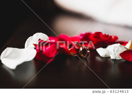 Beautiful toned picture with wedding rings against the background of a bouquet of flowers 63124613