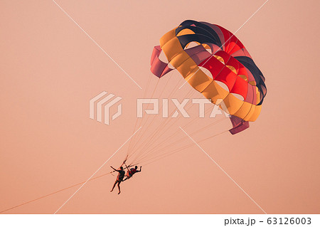 Parasailers Flying On Colorful Parachute In Sunset Or Sunrise Sky. Active Hobby 63126003