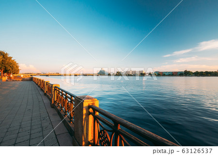 Riga Latvia. City promenade near Daugava River, National Library Building And Hotel Radisson Blu At Scenic Embankment Pier Under Blue Sky At Sunset Evening Time 63126537