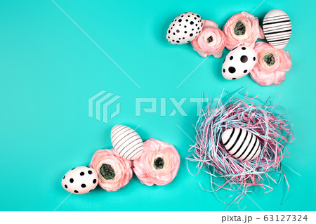 Decorative nest with creative graphic eggs and ranunculus flowers. Decorative nest with creative graphic eggs and ranunculus flowers. 63127324