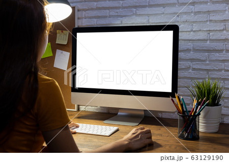 woman working empty screen computer mockup on wood desk in office. woman working empty screen computer mockup on wood desk in office. 63129190
