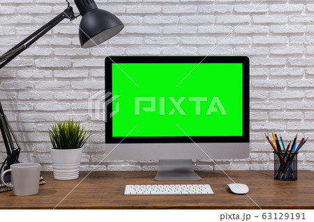 workspace with computer with blank white screen mockup, and office supplies on a wooden desk workspace with computer with blank white screen mockup, and office supplies on a wooden desk 63129191