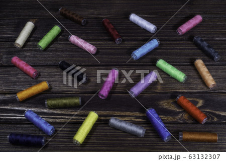 Group of differently colored spools perching Group of differently colored spools perching 63132307