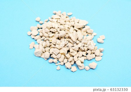 Zeolite mineral stone, zeolite pebbles isolated of blue background. Zeolite mineral stone, zeolite pebbles isolated of blue background. 63132330