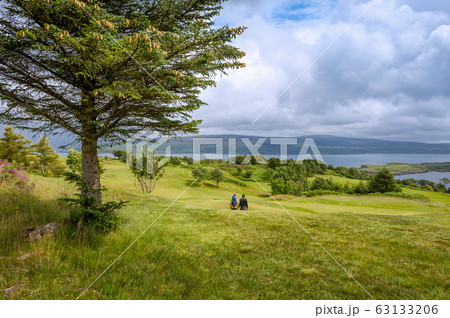 Tourist's couple walking at Islanf of Mull fields Tourist's couple walking at Islanf of Mull fields 63133206