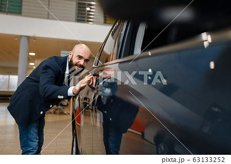 Man checks the paintwork of new automobile 63133252