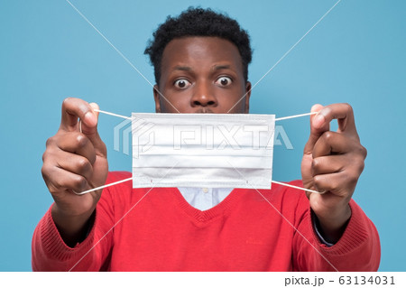 african american man using medical mask is shocked with coronavirus african american man using medical mask is shocked with coronavirus 63134031
