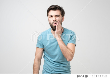 Guy wearing blue shirt with tooth ache isolated on white background Guy wearing blue shirt with tooth ache isolated on white background 63134706