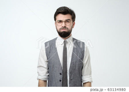 Young man looking camera puffing out cheeks from resentment. Young man looking camera puffing out cheeks from resentment. 63134980