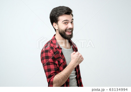 Happy successful young man screaming Yes and raising clenched fists 63134994