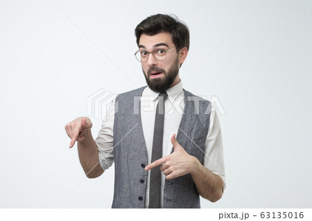 Modern young hispanic businessman pointing down on copyspace. 63135016