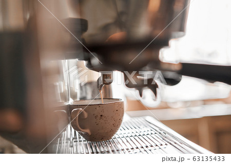small business, people and service concept. Bartender in apron with holder and tamper preparing coffee at coffee shop 63135433