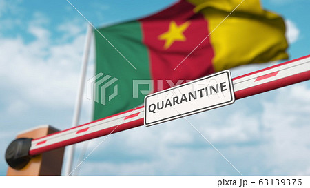 Closed boom gate with QUARANTINE sign on the Cameroonian flag background. Border closure or infection related isolation in Cameroon 63139376
