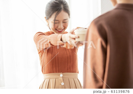 男性にプレゼントを渡す若い女性 63139876