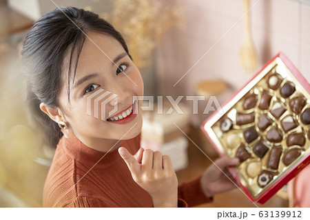チョコレートを選ぶ若い女性 63139912