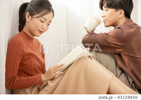 自室でリラックスする若いカップル 63139930
