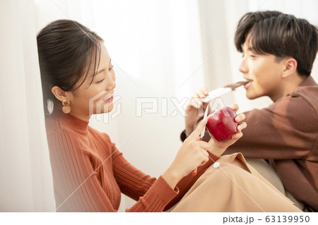 自室でリラックスする若いカップル 63139950