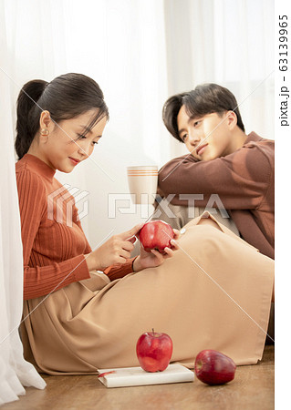 自室でリラックスする若いカップル 63139965