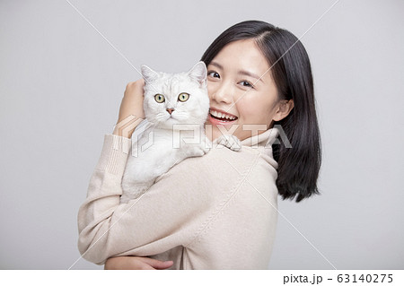 猫を抱きしめる女性のグレー背景ポートレート 63140275