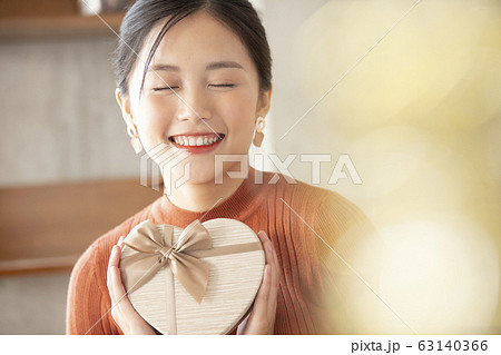 ギフトボックスを持つ若い女性 63140366