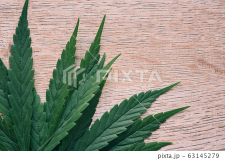 Marijuana leaf on wooden background top view - 63145279