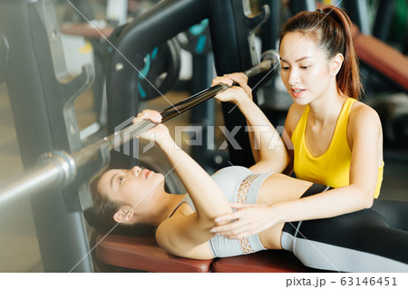 ベンチプレスをする女性とトレーナー ベンチプレスをする女性とトレーナー 63146451
