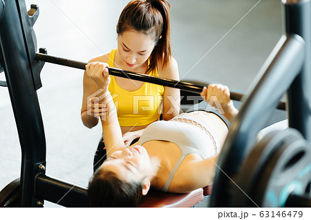 ベンチプレスをする女性とトレーナー ベンチプレスをする女性とトレーナー 63146479