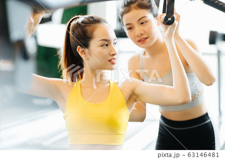 マシントレーニングをする女性とトレーナー マシントレーニングをする女性とトレーナー 63146481
