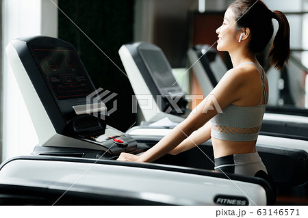 スポーツジムでランニングをする若い女性 63146571