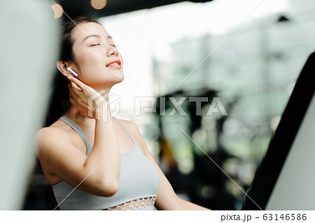 スポーツジムでリラックスをする若い女性 スポーツジムでリラックスをする若い女性 63146586