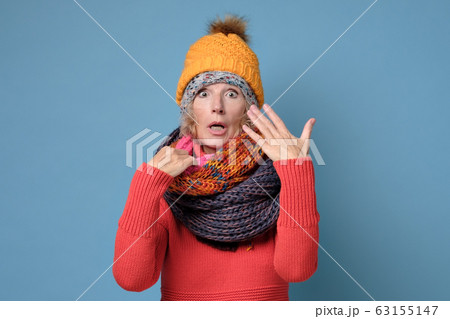 Senior woman in hats and scarfs is covered with sweat 63155147