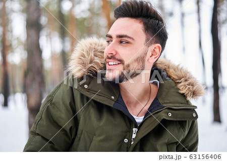 Attractive bearded man standing outdoors in winter 63156406