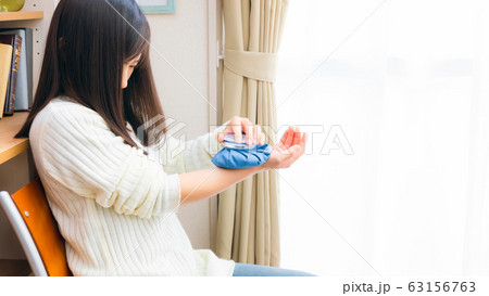 氷のうで手首を冷やす女性　16:9 63156763