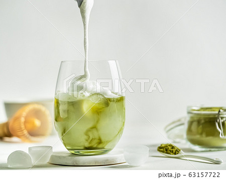 Iced Matcha Latte Tea with pouring whipped cream Iced Matcha Latte Tea with pouring whipped cream 63157722