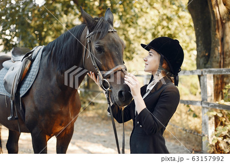 The rider in black form trains with the horse The rider in black form trains with the horse 63157992