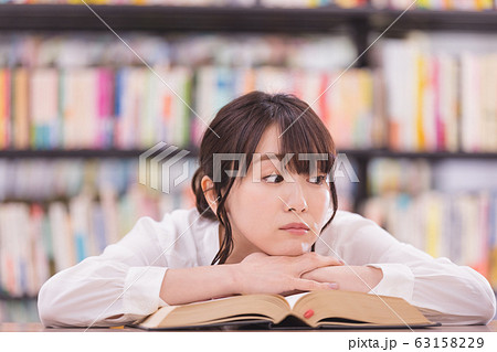 若い女性　うつ伏せ　考え事 63158229