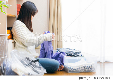 服を整理する女性 断捨離 リサイクル 衣替え 服を整理する女性 断捨離 リサイクル 衣替え 63159104